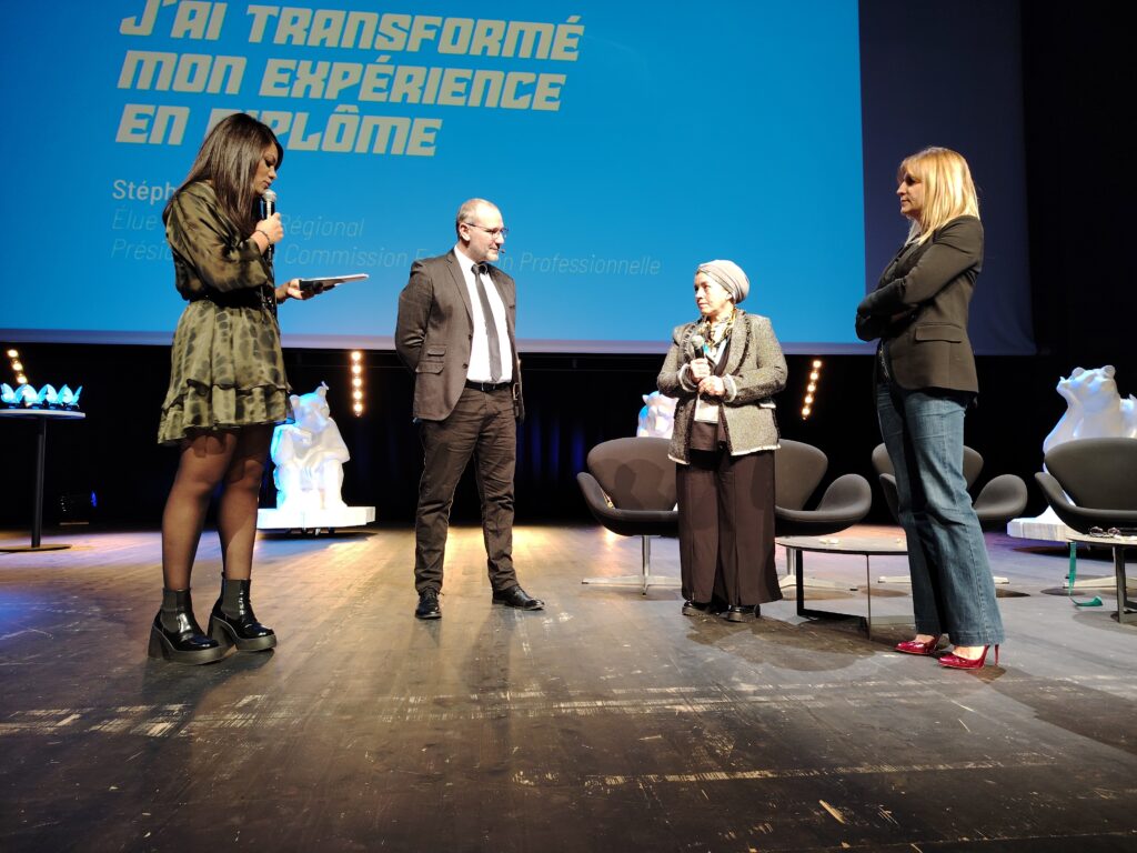 Lionel Lemaire, directeur général de Transitions Pro Grand Est échange avec la Mosellane Fatiha Findeisen (à droite de Lionel Lemaire) qui reçoit son trophée de la reconversion professionnelle.