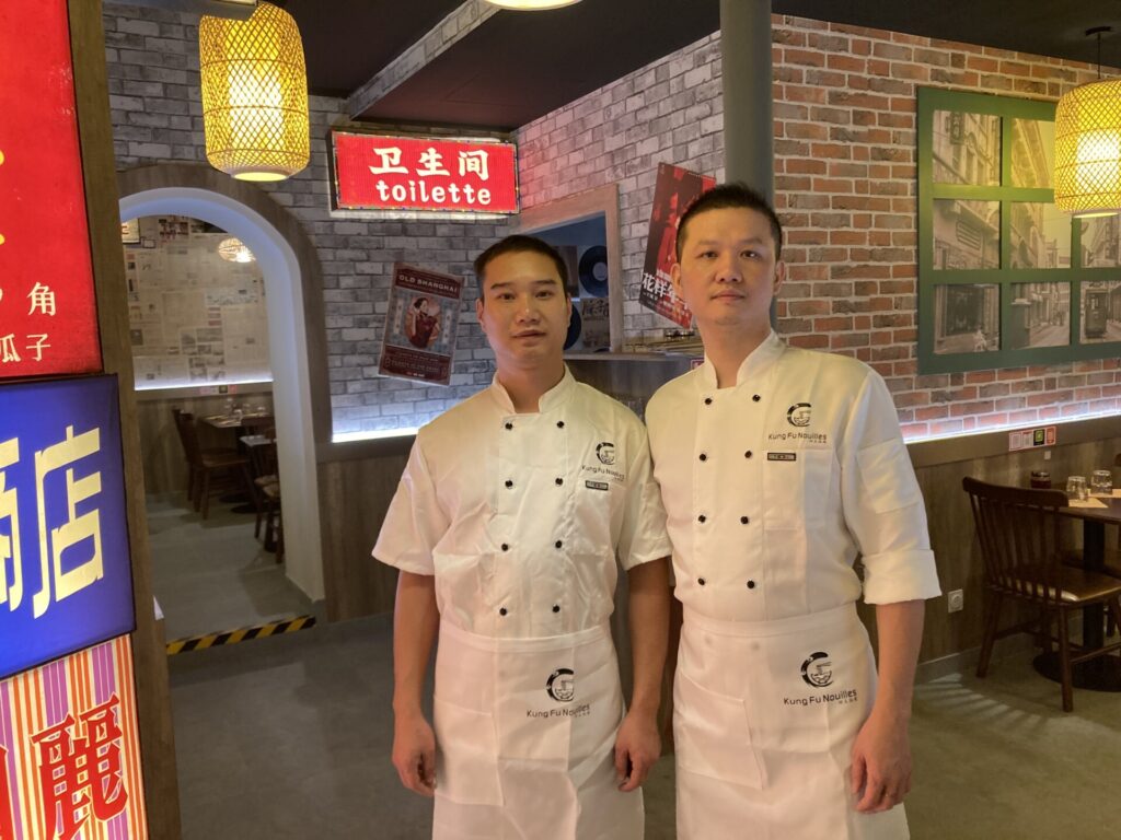 Tony Cai (à droite), gérant de Kung Fu Nouilles, et son cousin Shengmiao Ye (à gauche), qui confectionne les nouilles à la minute.